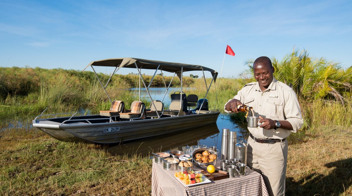 Botswana-andBeyondNxabega-Okavango-Tented-Camp-Guest-Delight-butler-setting-up-drinks-after-boat-ride